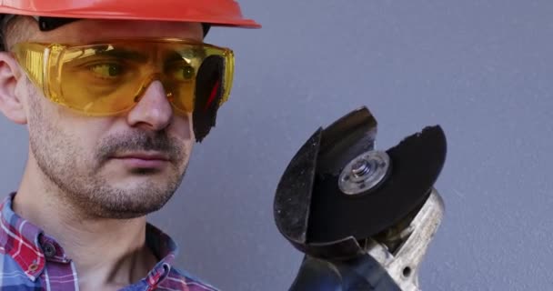 在灰色背景特写的护目镜下 部分锯片破碎的建设者 工人们认识到锯锯操作的固有危险 将防止事故的安全措施列为优先事项 — 图库视频影像
