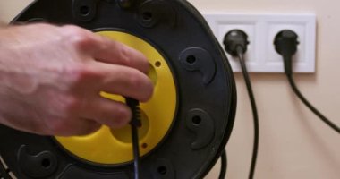 İnsan cihaz kablosunu oda prizi prizine bağlı hale getirir. İnsan, prizin yanındaki prizin prizine bağlı olan elektrik akışını sabitler.