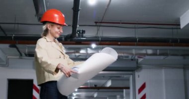 Miğferdeki kadın mühendis inşaat projesiyle iç çekmeyi karşılaştırıyor. Bayan yer altı otoparkında başını sallayarak hayal kırıklığını ifade ediyor.