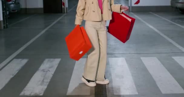 Snygg Kvinna Håller Shoppingväskor Dansar Övergångsstället Underjordisk Parkering Lady Uttrycker — Stockvideo