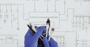 Elektrikçi, kabloların üzerinde elektrik şebekesi üzerinden üst görüş sağlayan farklı bujiler olan bir sürü kablo gösteriyor. Teknisyen, aygıt için plandaki bağlantıyı seçti