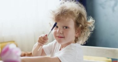 Hayal gücünün tuvalde canlanması gibi çocuk da gururla ışıldıyor. Her fırça darbesi kızı iç dünyayı ve duyguları ifade etmeye yaklaştırır.