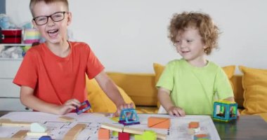 Mutlu kardeşler, inşaat seti detaylarıyla eğlenceli bir şekilde kavga ederler. Komik bebekler oyun odasında aktif oyun oynuyorlar. Aile hayatı