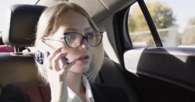 İş kadını, telefondan akıllı telefondan iş yerine giderken telefon eder. Kişisel asistanla iş konuşmaları konusunda kafası karışmış genç bayan konuşmaları.