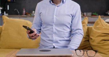 Akıllı telefonu ve dizüstü bilgisayarı olan bir iş adamı evde yakın çekim için hazırlanıyor. Girişimci telefon görüşmelerini kontrol ediyor. İnternetten sohbete katılıyor. Kanepede oturuyor.