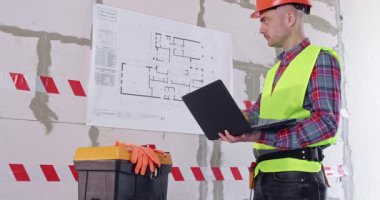 Miğferli miğfer dizüstü bilgisayarla hesaplama yapar. Mühendis, kat planının çalışma sürecini hızlandırmak ve otomatik hale getirmek için modern teknolojiler kullanıyor