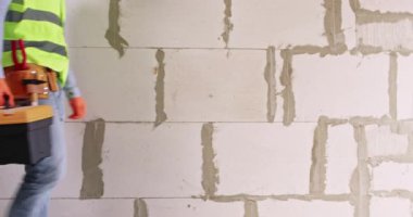 Adam apartmanda yapılan işlerin kalitesini ölçmek için kömür bloğu duvarının yüzeyine dokunuyor. Mühendis özel alet çantası taşır ve görevleri tamamladıktan sonra odayı terk eder