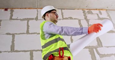 İnşaatçı tadilattan önce tavan ve inşaat düzenini kontrol eder. Miğfer uzmanları zemin planlarını ellerinde tutuyor. Kömür duvarına karşı çalışma alanlarını değerlendiriyor.