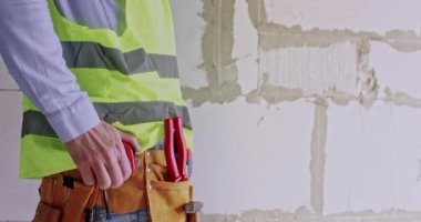 Mühendis blok duvarının genişliğini hesaplamak için mezura kullanıyor. Özel araçla iş giyimi ölçüm odasında profesyonel ve özel görevlere başlamaya hazırlanıyor