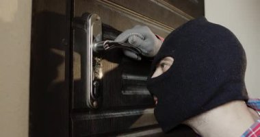 Siyah kar maskeli bir hırsız kapı kilidine yanlış anahtarı sokuyor. İnsan keskin tıkırtı sesinden kaçınmak için anahtarı yavaşça çevirir. Adam ayak seslerini ya da ayak seslerini dikkatle dinliyor.