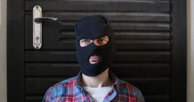 Siyah kar maskeli tehlikeli bir hırsız apartman kapısının kolunu çekti. Adam güvenlik kapısını açmaya çalışıyor ve parlak anahtarı kaldırıyor. Eleman kolu çekip anahtarı gösteriyor.