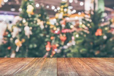 Boş ahşap masa üstü, bulanık Noel ağacı ve bokeh ışıklı arka plan