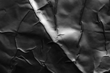 black crumpled and creased plastic poster texture background