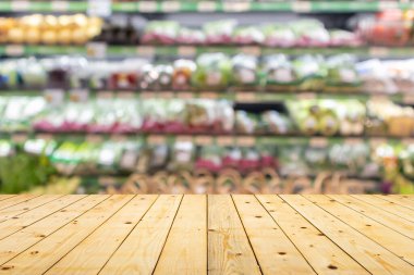 Marketteki raflarda sebzelerle kaplı ahşap masa üstü bulanık arka plan