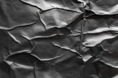 black crumpled and creased plastic poster texture background