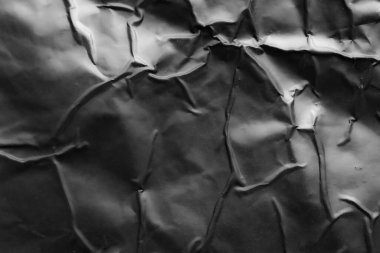 black crumpled and creased plastic poster texture background