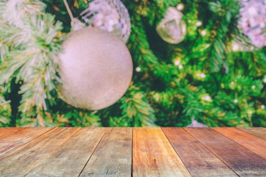 Boş ahşap masa üstü, bulanık Noel ağacı ve bokeh ışıklı arka plan