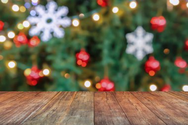 Boş ahşap masa üstü, bulanık Noel ağacı ve bokeh ışıklı arka plan