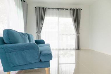 Oturma odasındaki mavi kanepe. Evin arka planı.