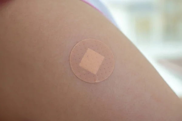 Vaccinated little asian girl with adhesive plaster after vaccine injection