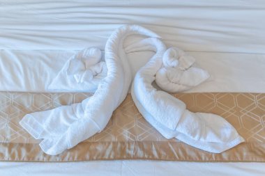 Clean white bath towels on the hotel bed