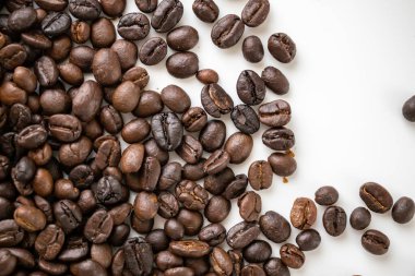 Fresh roasted brown coffee beans on white background