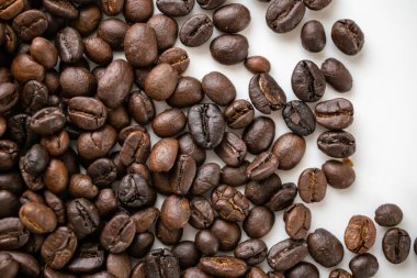 Fresh roasted brown coffee beans on white background