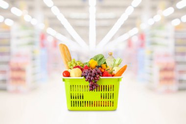 Markette sebze ve meyve dolu alışveriş sepeti bulanık arka plan