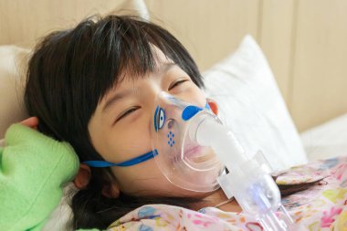 Solunum tedavisi için nebulizör solumuş küçük Asyalı kız.