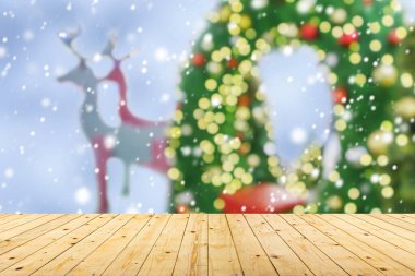 Boş ahşap masa üstü, bulanık Noel ağacı ve bokeh ışıklı arka plan