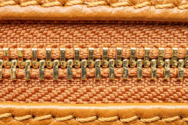 Kahverengi deri çantanın fermuarını kapat.