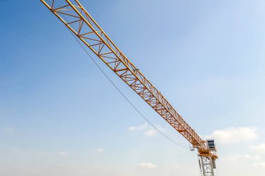 İnşaat alanında mavi gökyüzü arka planına sahip endüstriyel vinç.