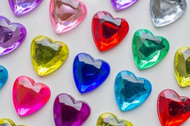 Beyaz kağıda yapıştırılmış kalp şeklinde mücevher çıkartması.