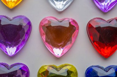 Beyaz kağıda yapıştırılmış kalp şeklinde mücevher çıkartması.