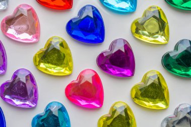 Beyaz kağıda yapıştırılmış kalp şeklinde mücevher çıkartması.