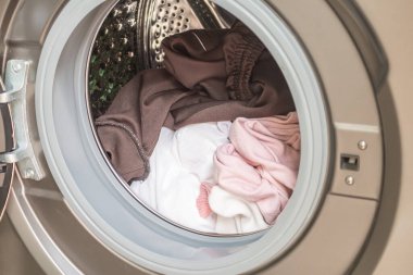 Çamaşır makinesi giysilerle dolu.