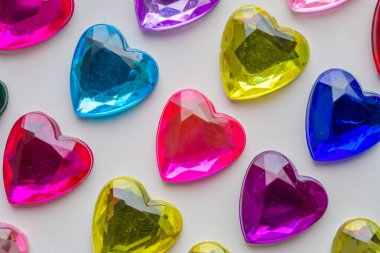 Beyaz kağıda yapıştırılmış kalp şeklinde mücevher çıkartması.