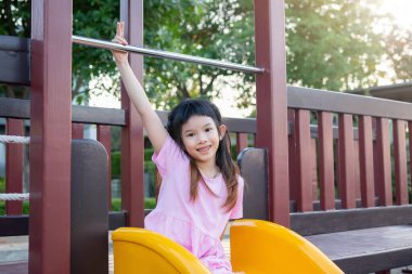 Parktaki kaydırakta oynayan tatlı Asyalı kız.
