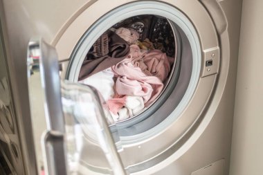 Çamaşır makinesi giysilerle dolu.