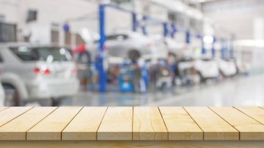 Boş ahşap masa üstü ve araba servisi merkezi oto tamir atölyesi bulanık arkaplan