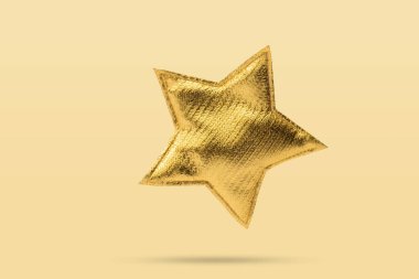Sarı arka planda izole edilmiş altın Noel yıldızı süsü.