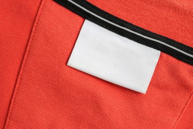 Boş beyaz çamaşırhane kıyafetleri turuncu gömlek kumaş arka planda etiketi