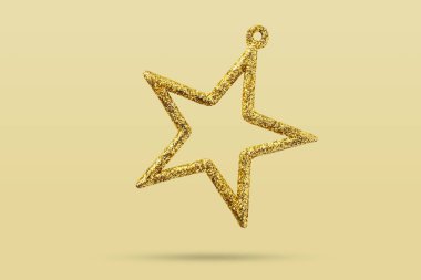Sarı arka planda izole edilmiş altın Noel yıldızı süsü.