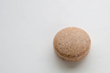 Beyaz arka planda kahverengi bitkisel hap tableti