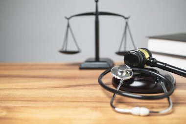 Personal injury law concept. The midsection of the judge's room has a gavel, stethoscope on the desk is a unique concept, symbolizing the intersection of justice, and health in a courtroom. copy space clipart