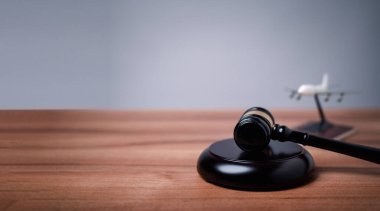 Göçmen bürosu yetkilisi, göçmenlik yasalarına uymanın önemini ve yasayı çiğnemenin sonuçlarını sembolize ederek adalet tokmağını masaya indirdi..