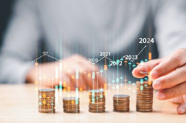 businessman analyzing stock trading graph financial data. Coins tower stacked on desk wooden, Business finance and saving money investment, Money coin stack growing graph concept. Balance savings.
