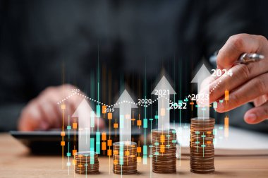 businessman analyzing stock trading graph financial data. Coins tower stacked on desk wooden, Business finance and saving money investment, Money coin stack growing graph concept. Balance savings.