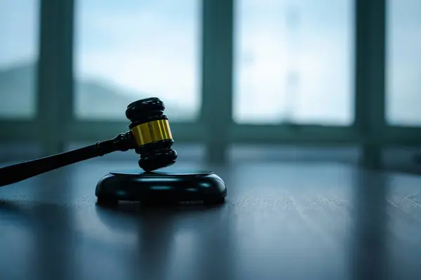 Yargıcın mahkeme salonundaki otoriter tokmak grevi adalet ve nihai hissi getirdi, tıpkı bir müzayedecinin ahşap masası gibi, hukuk ve düzen kavramını sembolize ediyordu..