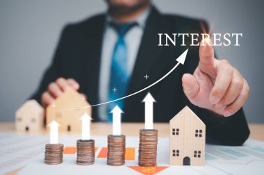 Becerikli bir yatırımcı, faiz oranlarını, yatırım olanaklarını ve kredi seçeneklerini titizlikle tartarak finansal refahlarını artırmaya çalışır. bankacılık, satın alma, borç, para, mortgage, işletme, finans